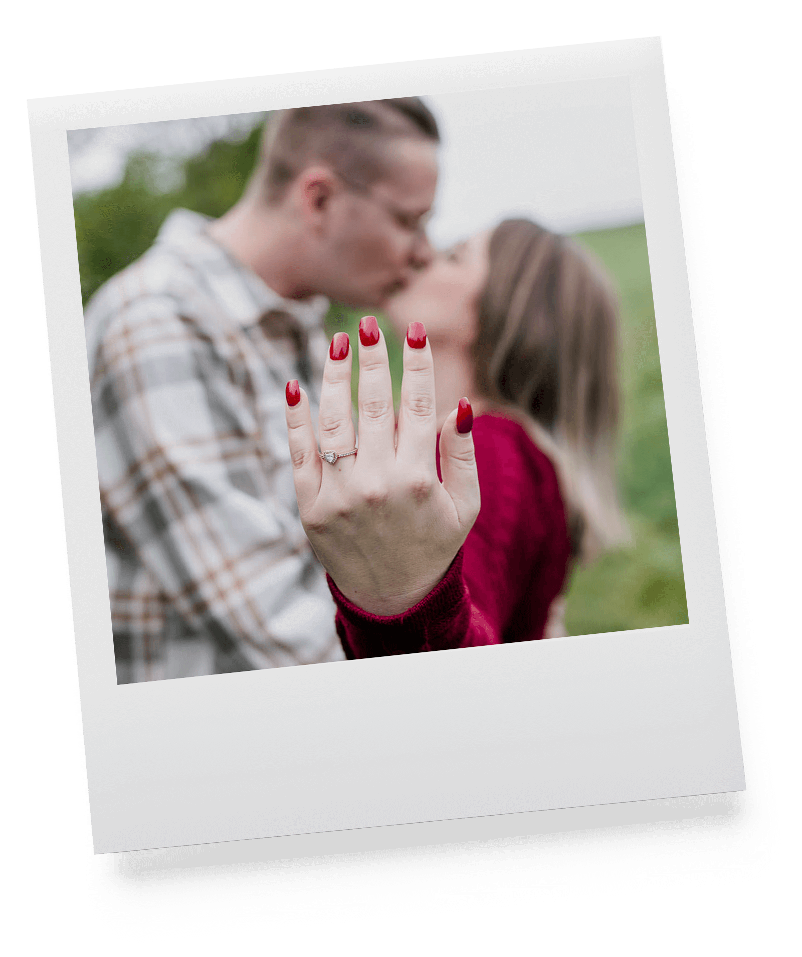 Paar küsst sich und Frau hält ihren Verlobungsring beim Fotoshooting in die Kamera